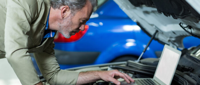 mechanic-using-laptop-while-servicing-car-engine